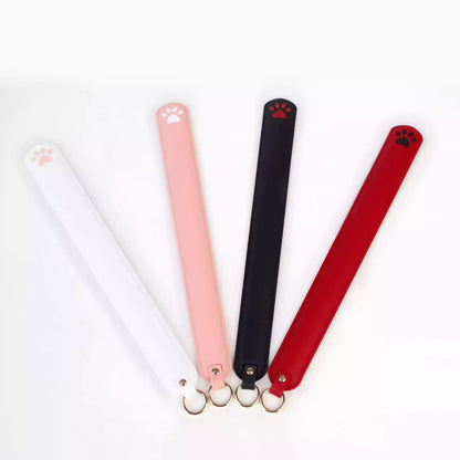 Black, red, white and pink silicone cat paw paddles displayed together