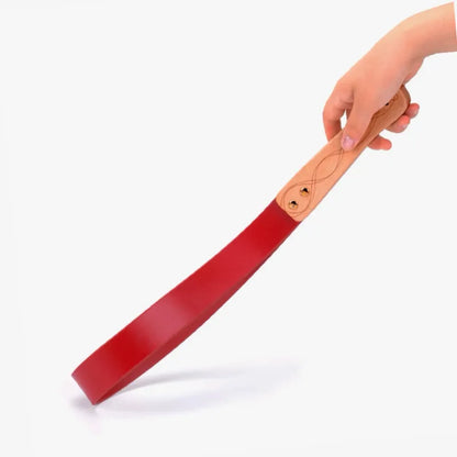 Red leather paddle with carved wood handle full view